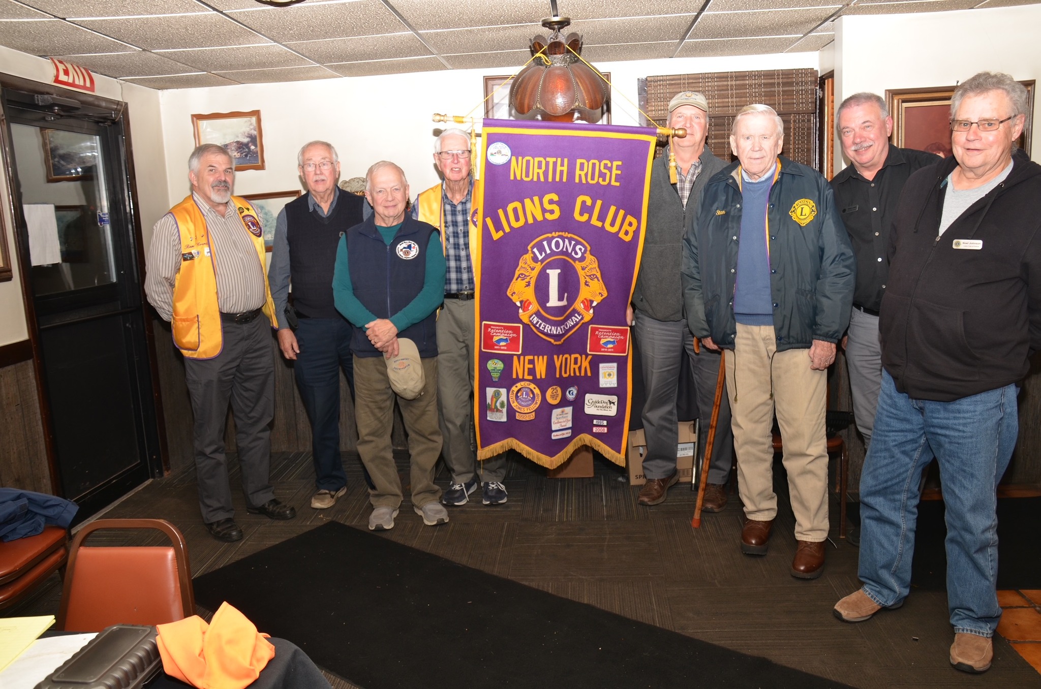 group of North Rose Lions Club members with their banner