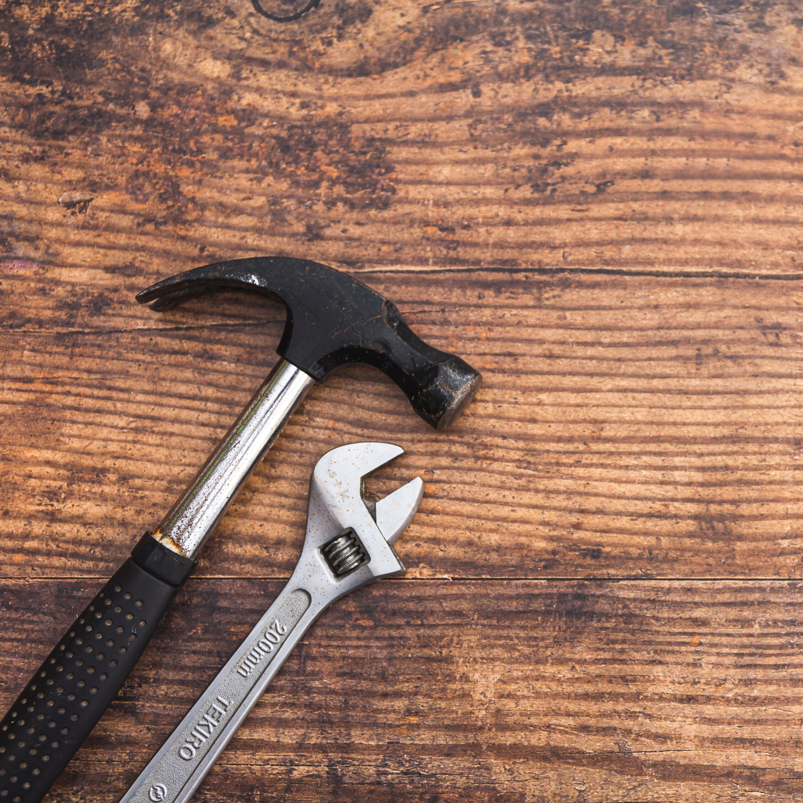 hammer and wrench on a wooden surface